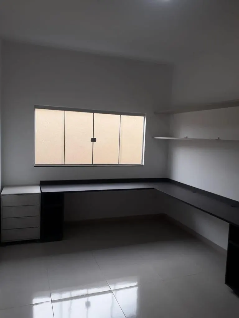 Home office com bancada sob a janela