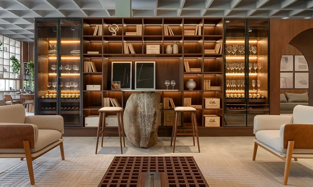 Sala com estante de madeira do chão ao teto e poltronas